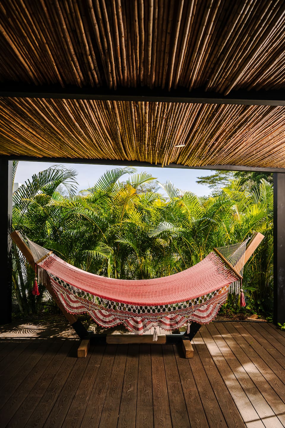 A woven hammock on the covered terrace, palms behind