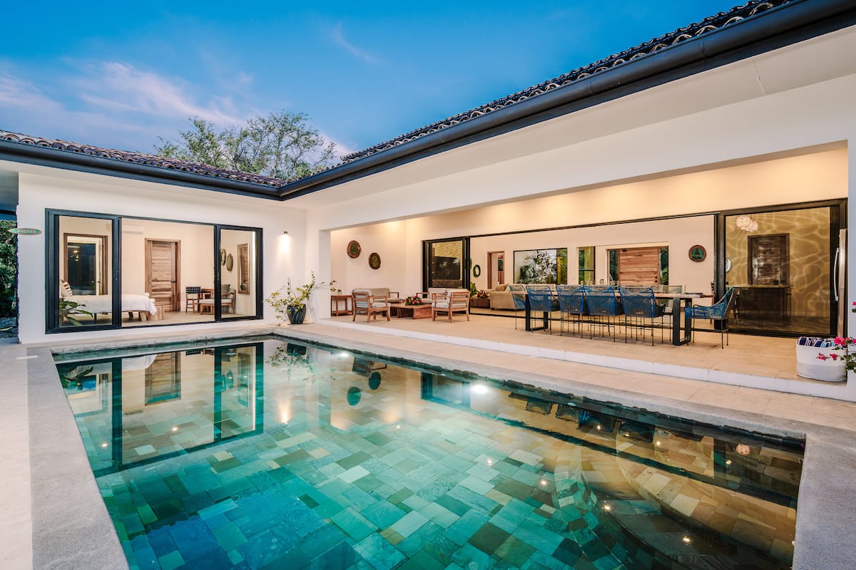 Villa Reserva 101 wrapped around its pool at blue hour