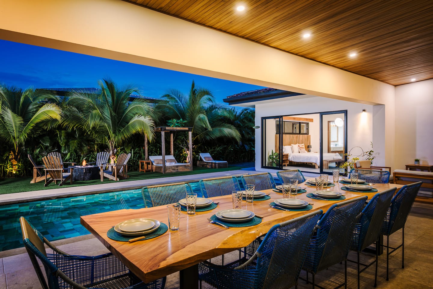 Villa Reserva 101's long table on the covered terrace at dusk, beside the pool