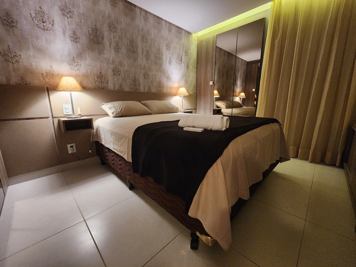 חדר עם עיצוב נעים, בצבעים רכים כמו בז' וחום בהיר, שמעבירים שלווה ונוחות. מיטת קווין סייז מציעה תמיכה מצוינת לשינה נינוחה בלילה, עם מצעים נעימים.