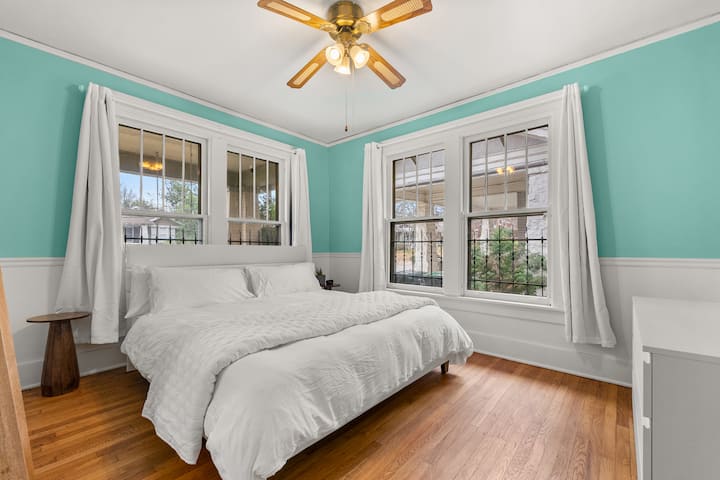 Drift off in comfort on the king bed’s green tea mattress with blackout curtains, or wake to natural light from the beautiful sunrise and a street view of this charming neighborhood in this inviting bedroom.