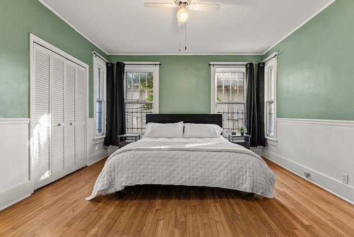 A restful retreat awaits in this bedroom, complete with a comfortable King-size bed and calming green tones.