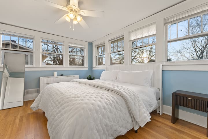 Bask in the open, airy feel of this upstairs bedroom, where many windows showcase a great sunset view, filling the space with warm, golden hues.