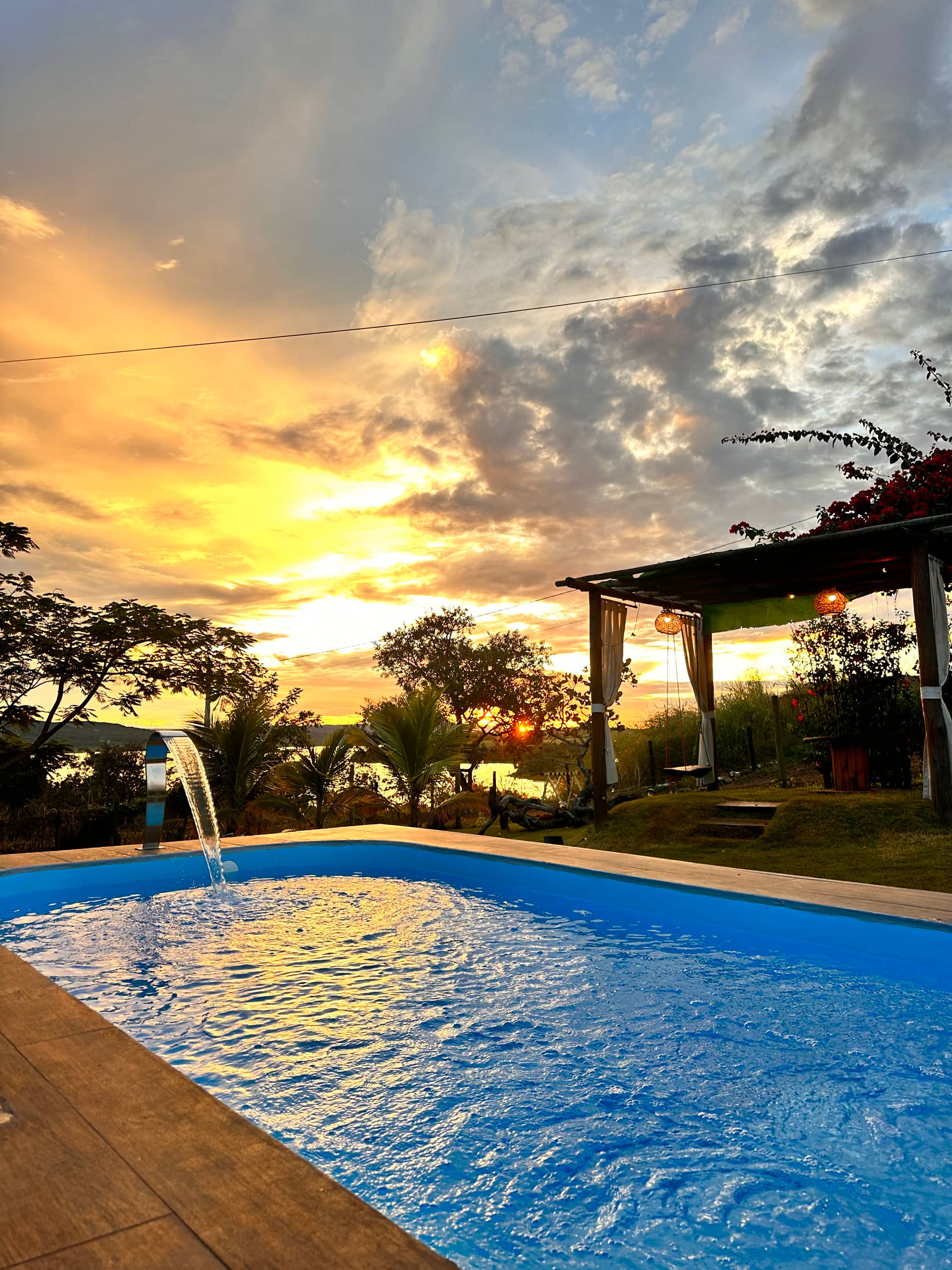 Pôr do sol dourado visto da piscina do Chalé Pôr do Sol