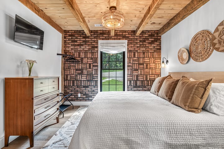Main floor bedroom features a king bed, two nightstands, dimmer switches, ceiling fan, smart tv with wi-fi & 6 clothes hangers.
