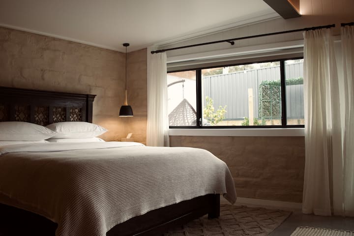Original mud brick walls, carefully preserved and celebrated as part of the character in this space.