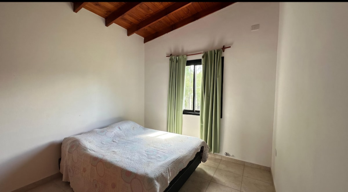 Habitación principal con cama matrimonial cuenta con ropero y ganchos.