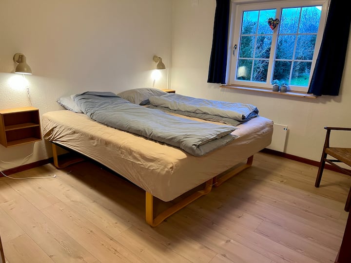 เตียงคู่ตู้เสื้อผ้าบิวท์อินพร้อมบาร์ไม้แขวนเสื้อและตู้เสื้อผ้าในห้องนอน