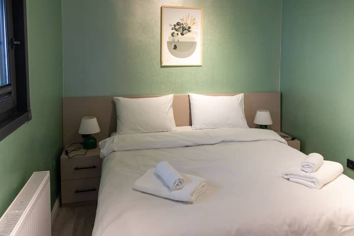 Lákavá spálňa s útulnou manželskou posteľou, lampičkami pri posteli a príjemným osvetlením pre pokojný pobyt.