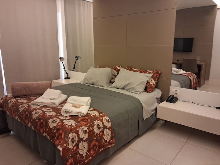 Grote en vrij comfortabele kamer. Queensize bed, nachtkastjes met scharnierende armaturen.
In het raam, verduistering. Boven de bijzettafels, spiegel aan beide kanten