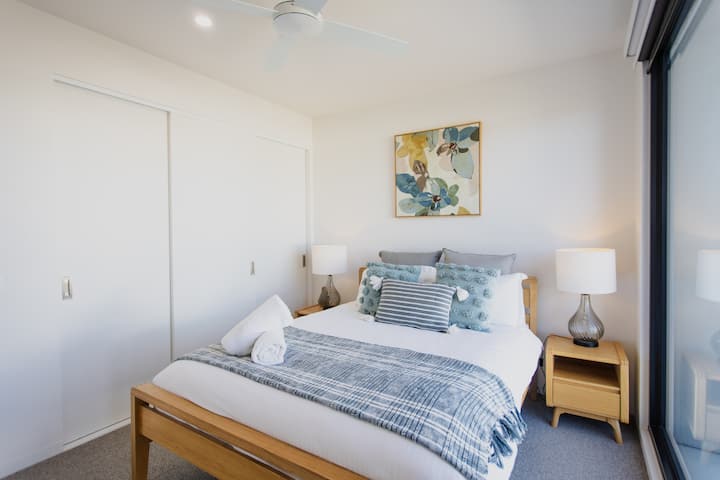 Chambre lumineuse avec un lit confortable et un décor frais et accueillant
