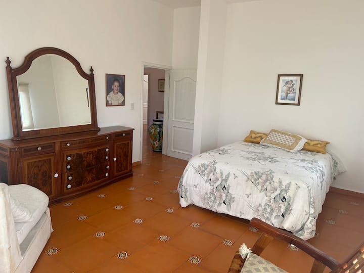Chambre à coucher accueillante avec meuble en bois massif.