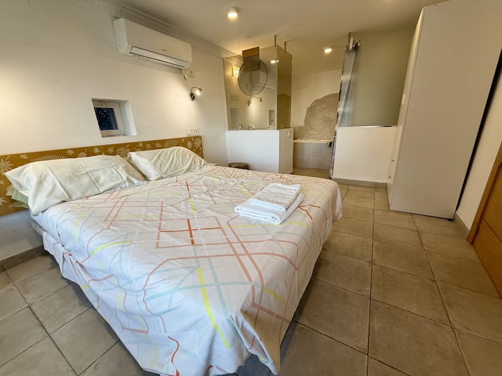 Bedroom 2, the "rock room" ; a very unusual bedroom with ensuite and pool view, direct access to pool area ; the end wall in the bathroom is the rock from hilltop.