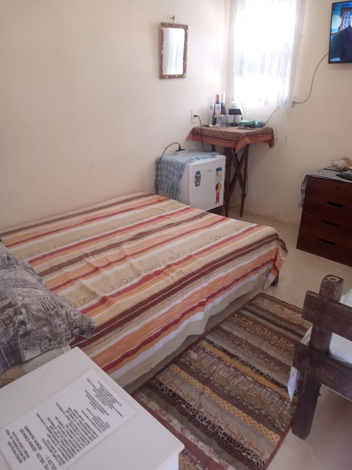 غرفة نوم واحدة مع بار صغير وتلفزيون 