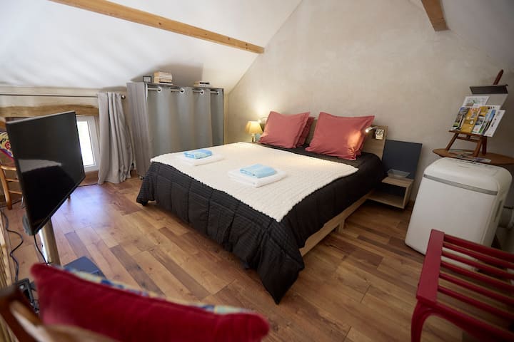 In the mezzanine bedroom with wooden floors, the very comfortable queen size bed, made on your arrival, awaits you.
At your disposal, luggage rack, air conditioner, TV, wardrobe with shelves and 8 hangers, two vintage straw chairs.