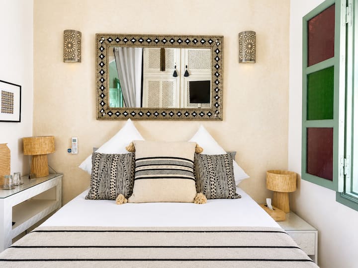 Petite Kasbah a tout d’une grande, Chambre cosy avec lit double, TV, placard, climatisation et Wi-Fi HD. Double vue sur la coursive du riad et le patio au cœur de la médina de Marrakech.
