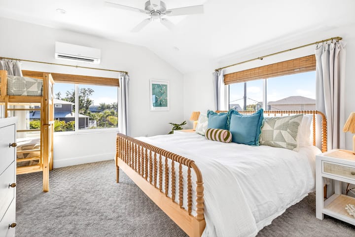 Guest bedroom on upstairs level with King bed, twin bunk beds, luxe hybrid mattresses and bedding, blackout curtains, sound machine, ceiling fan, mini-split for customized sleeping temp, ensuite bathroom, and Roku smart TV.