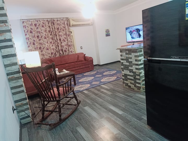 sala de estar con sofá, sofá cama y televisor inteligente.