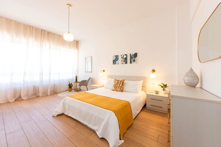 Grote en gastvrije slaapkamer met queensize bed, grote ramen en veel ruimte om te ontspannen of te werken.
