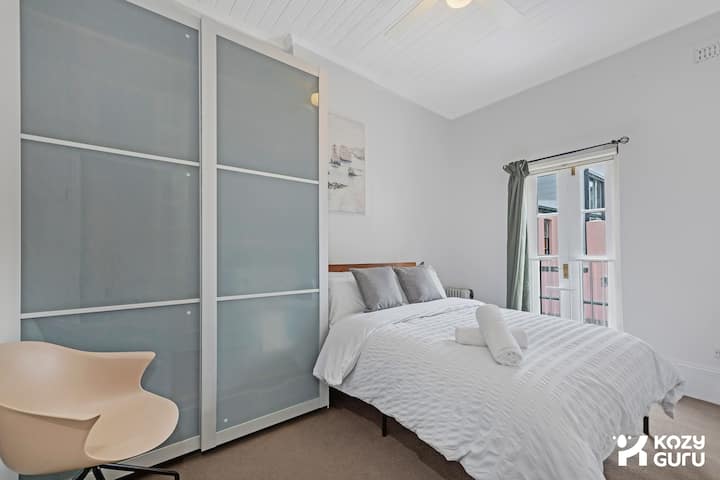 A tidy and tranquil bedroom featuring sleek, modern wardrobe storage.