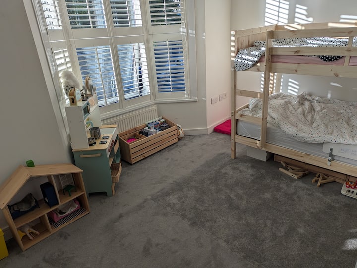 Une chambre d'enfant avec des lits superposés, des livres et des jouets. Peut accueillir le matelas pneumatique double si vous préférez.