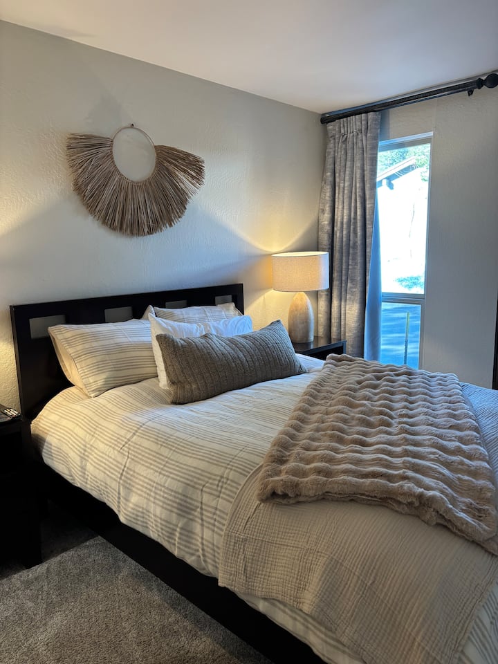 标准双人床，配备套房、衣橱和电视。 