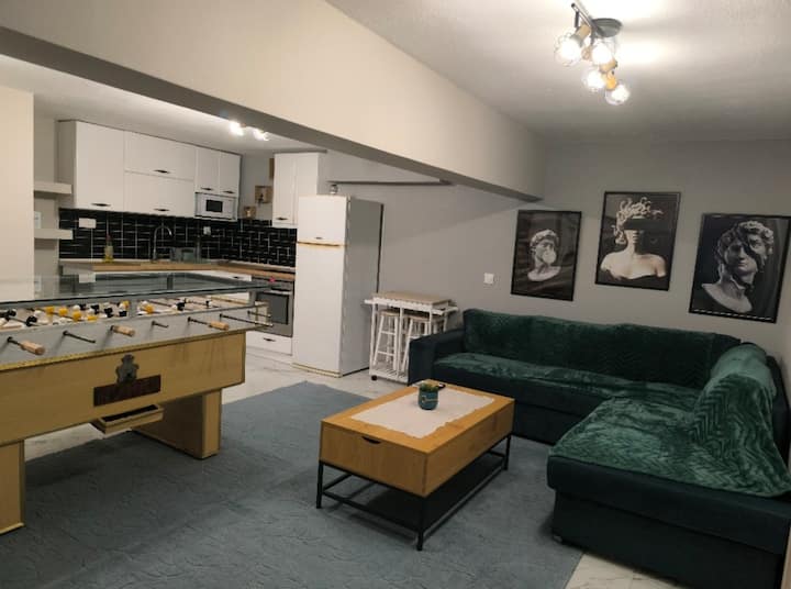 Sebule yenye nafasi kubwa na ya kuvutia iliyo na sofa kubwa ya kona, televisheni mahiri ya inchi 65 na jiko lenye vifaa kamili. Inafaa kwa ajili ya kupumzika na kuburudisha.