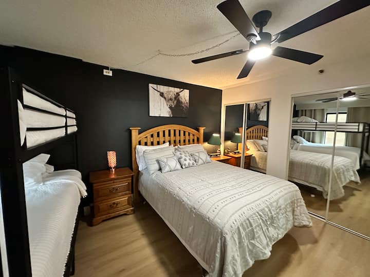 Este dormitorio cuenta con una cama tamaño queen y una litera tamaño queen, que ofrece un cómodo espacio para dormir para varios huéspedes.