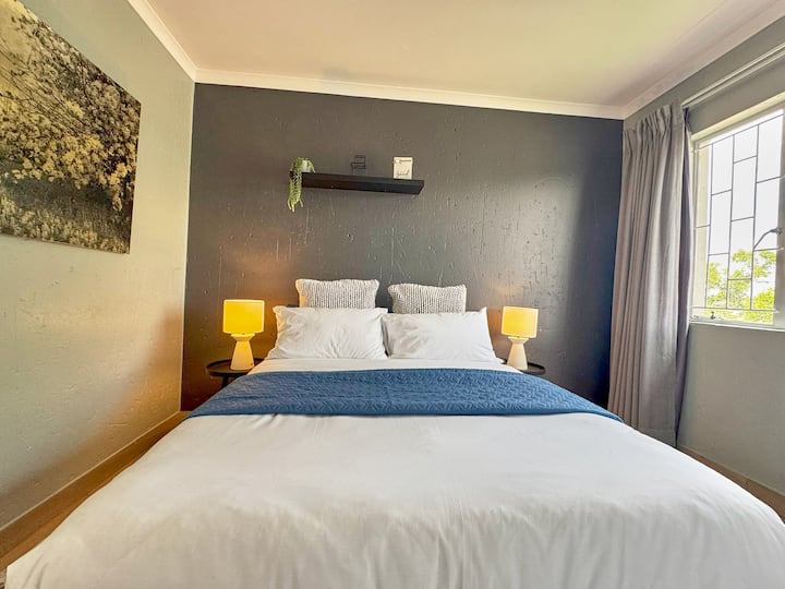 חדר שינה שקט עם מצעים לבנים נקיים ועיצוב נעים לשינה רגועה.