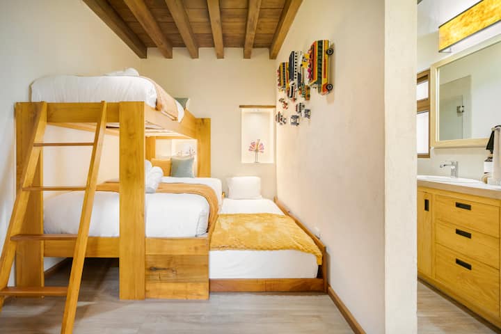 Chumba nambari 2 kiko kwenye ghorofa ya kwanza ya nyumba, kina bafu kamili, kitanda cha watu wawili na vitanda viwili pacha, pamoja na kabati la kuweka nguo zako, televisheni na sehemu ndogo ya kukaa na kusoma kimya kimya!