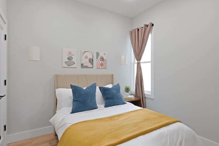 Posteľ v plnej veľkosti s inteligentným televízorom namontovaným na stene