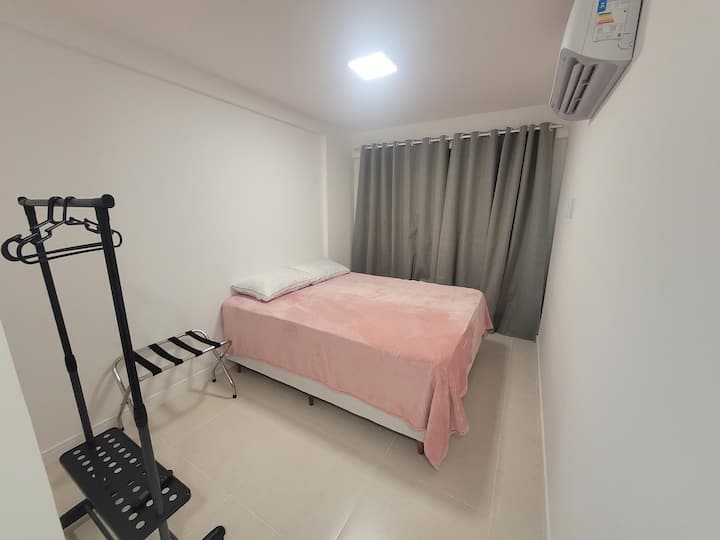 Suite con cama tamaño queen, perchero, portaequipajes, aire acondicionado y cortinas opacas