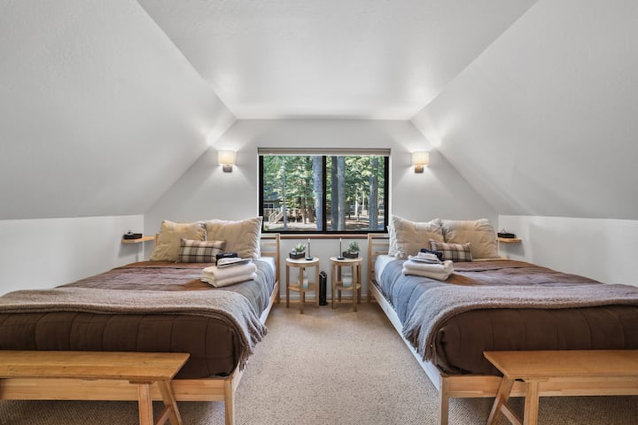 Peaceful queen bedroom with forest views, soft lighting, and cozy bedding.