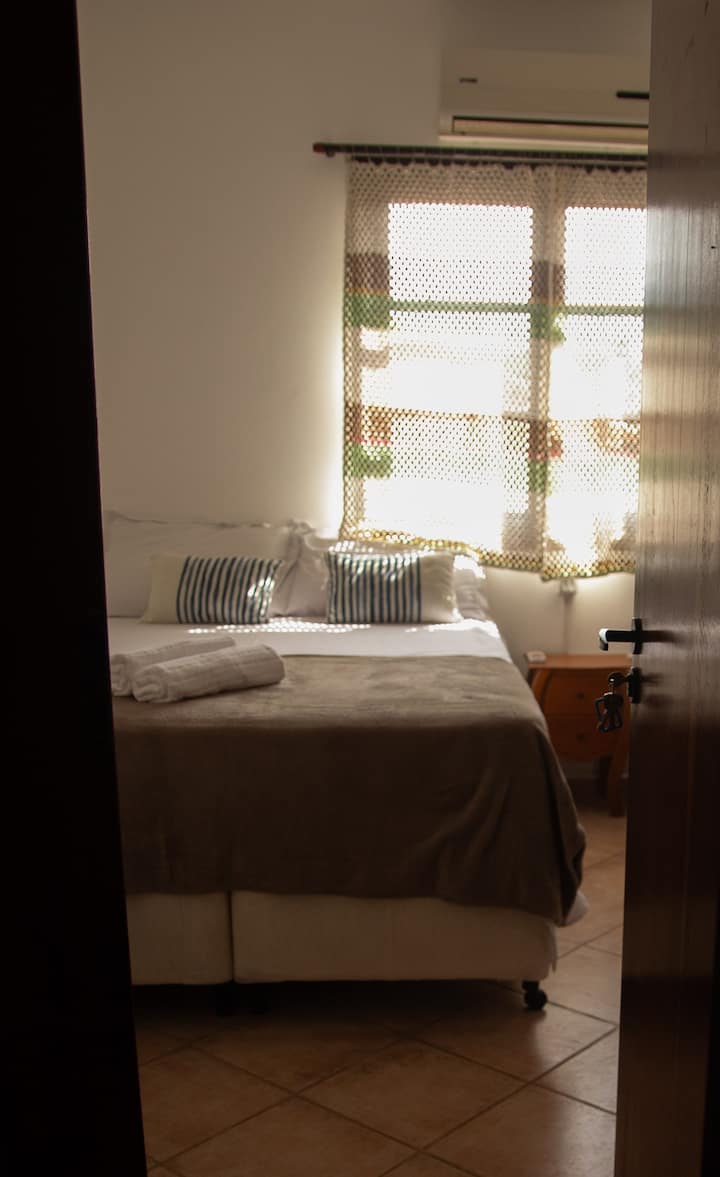 2号套房，通风良好，配有吊扇、空调、镜子和衣柜。