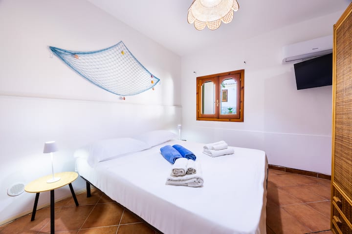 Una habitación con TV, aire acondicionado, armario, ventana,