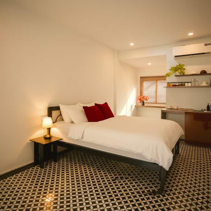 Le studio dispose d'un éclairage chaleureux et confortable pour des soirées de détente et d'un lit king-size confortable avec un matelas à ressorts. Il est situé dans un quartier historique de logements de la fonction publique au cœur du District 1, HCMC, qui évoque l'atmosphère du vieux quartier de Hanoï