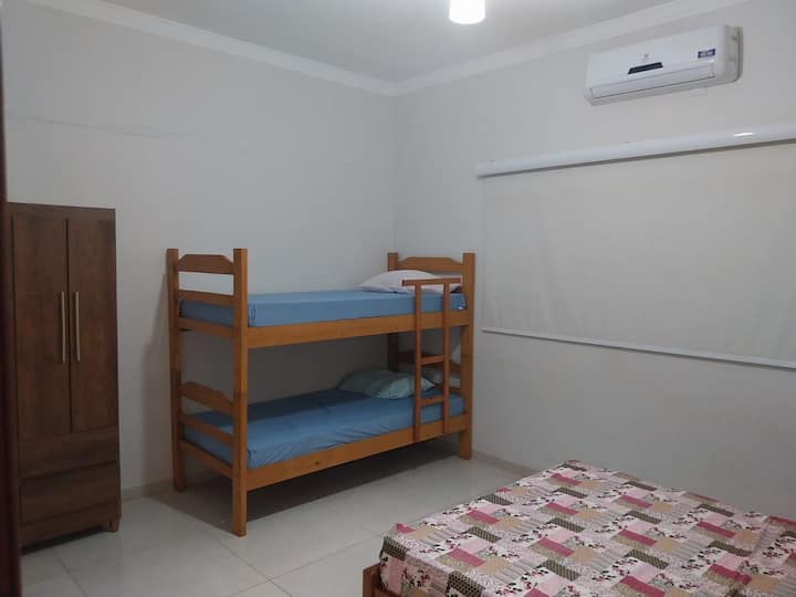 جناح يحتوي على مكيف هواء ومروحة وسرير مزدوج وسرير بطابقين وخزانة، مع توفير الوسائد. 
