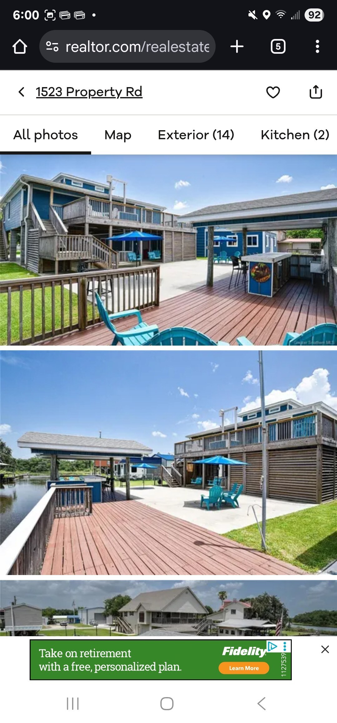 An expansive deck area features multiple lounge chairs arranged for relaxation, overlooking a tranquil waterway. A covered seating area provides shade, while bright blue accents are visible throughout the outdoor space, creating a serene environment ideal for unwinding.