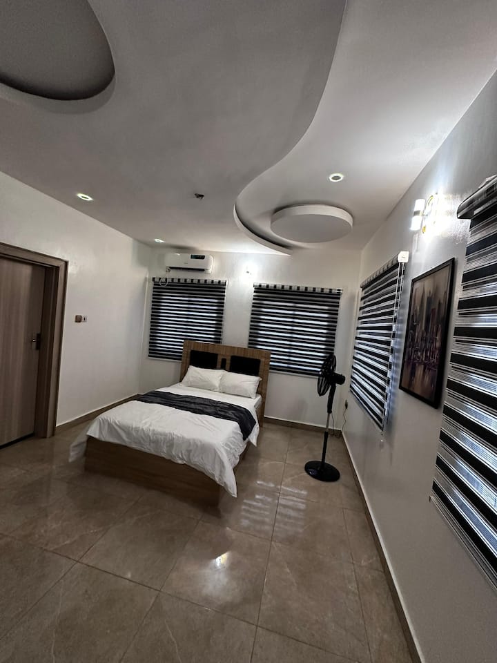 Chumba hiki cha kulala chenye nafasi kubwa cha Port Harcourt kinatoa kitanda chenye starehe cha watu wawili, mapambo maridadi na mazingira tulivu. Inafaa kwa wanandoa, marafiki, au wataalamu wanaotafuta kifupi cha kupumzika, cha kisasa cha Airbnb.