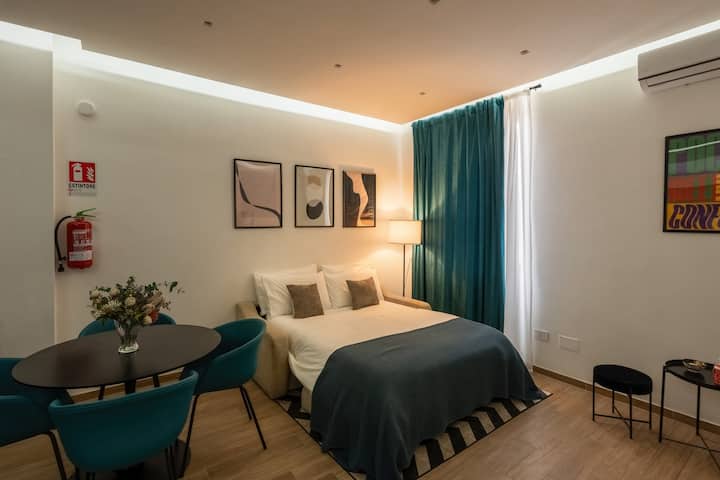 Área de estar ampla e elegante, o coração do apartamento, com sofá-cama com sobrecolchão macio para um descanso perfeito, smart TV de 55" e ar-condicionado quente/frio de última geração.