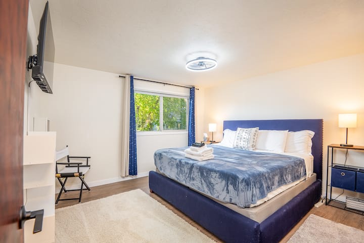 Hlavná spálňa má televízor Roku, obojstranný ventilátor, zatemňovacie závesy, malý priestor na stôl, praktické police a šatník. Skriňa obsahuje koše a organizéry na usporiadanie vecí. 