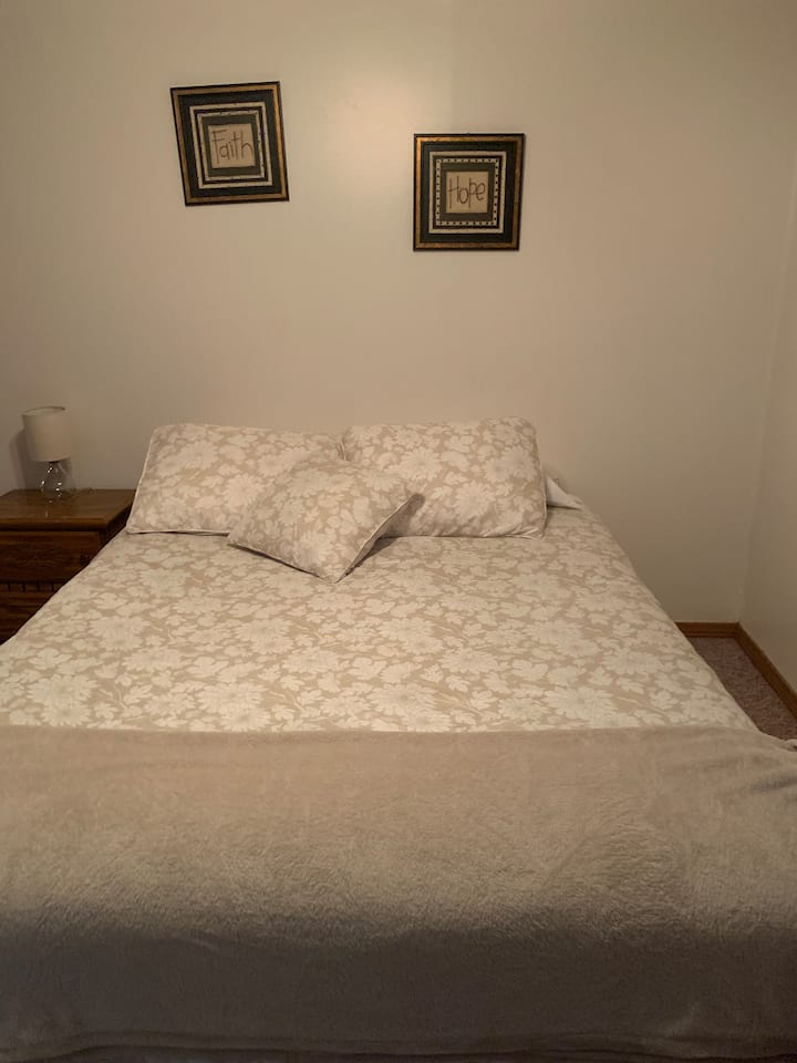 Легло „Queen size“ с скрин, скрин с чекмеджета и нощно шкафче. Климатик на прозореца и Roku TV.