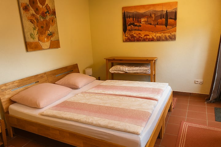 Светло, тивко прибежиште со директен пристап до дворот. Јасниот дизајн ве поканува да се опуштите – идеално за добар сон и опуштени утрински часови со поглед кон селата.