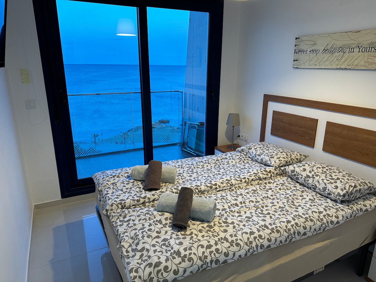 להתעורר לים התיכון – חדר שינה ראשי מואר ושקט עם דלת הזזה למרפסת. נוף ים פנטסטי.