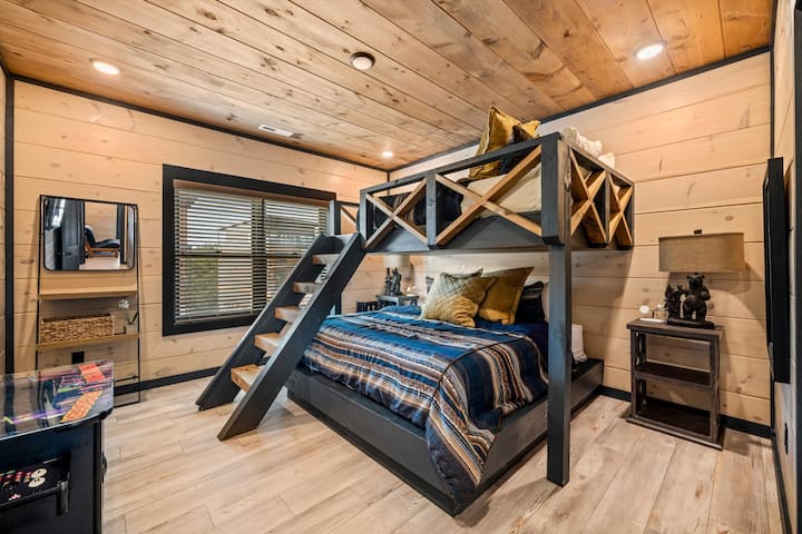 Rustic bunk room with queen bed below and cozy loft above