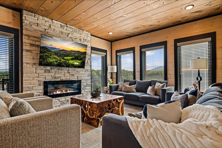 Cozy mountain-style living room with stone fireplace and scenic views
