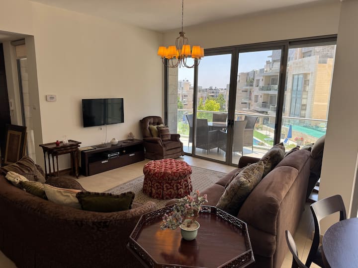 Çlodhu në këtë hapësirë të ngrohtë dhe ftuese jetese që ndërthur në mënyrë të përkryer rehatinë dhe elegancën. Me ndenjëse prej pelushi, një televizor me ekran të sheshtë dhe një tavolinë kafeje elegante, kjo dhomë është projektuar për relaksim, argëtim dhe kohë cilësore me të dashurit.
