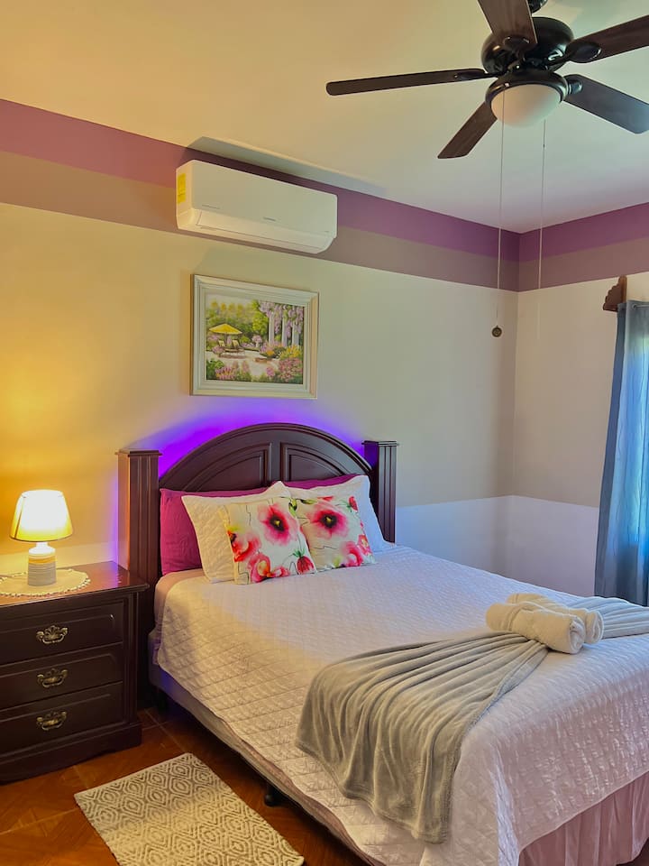 Amplia, cómoda y privada habitación equipada con: 1 cama queen, A/C, cabezal iluminado, ventana con vista al jardín,  ventilador de techo, amplio closet, lampara y gaveteros.
