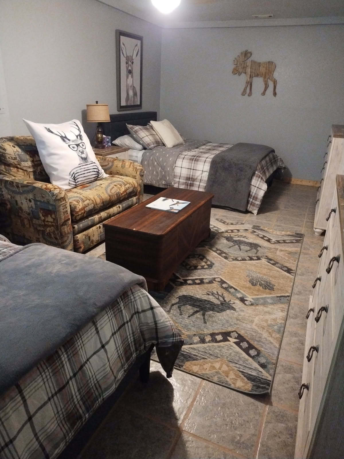 غرفة نوم كبيرة في الطابق السفلي مع سريرين بحجم كوين وخزانتين وأريكة صغيرة قابلة للسحب. 