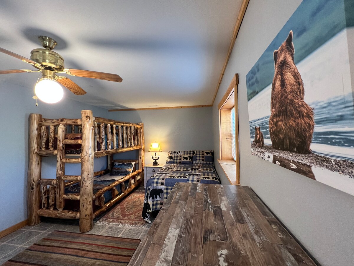 غرفة نوم كبيرة في الطابق السفلي مع سرير بطابقين وسرير كامل الحجم